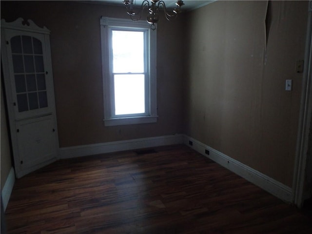 unfurnished room with dark hardwood / wood-style flooring and a chandelier