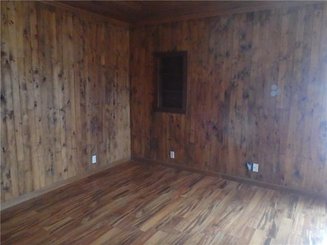 unfurnished room with dark wood-type flooring and wood walls