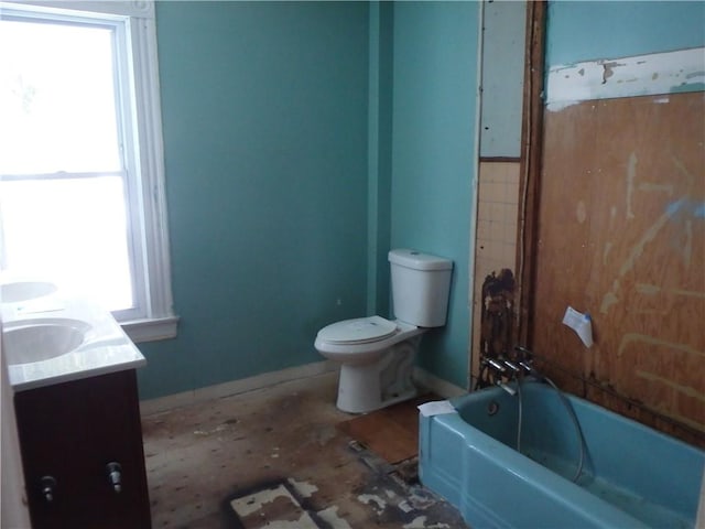 bathroom featuring toilet, a washtub, and vanity