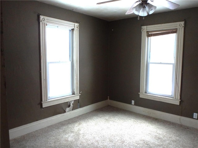 carpeted spare room with ceiling fan and a healthy amount of sunlight