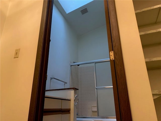 bathroom featuring lofted ceiling with skylight