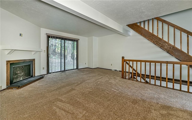 unfurnished living room with a textured ceiling, beam ceiling, and carpet floors