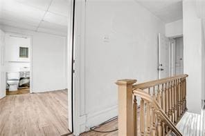 corridor with hardwood / wood-style flooring and a paneled ceiling