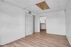 empty room with a paneled ceiling and hardwood / wood-style flooring