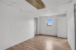 spare room featuring a paneled ceiling and hardwood / wood-style floors