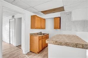 kitchen featuring light hardwood / wood-style floors and a drop ceiling