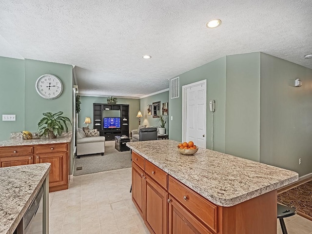 kitchen with a kitchen bar, crown molding, a textured ceiling, and a kitchen island