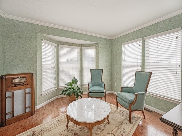 living area featuring wood-type flooring and crown molding