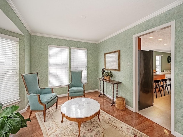 sitting room featuring a wealth of natural light, light hardwood / wood-style flooring, and crown molding