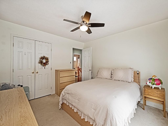 bedroom with ceiling fan, a closet, and light carpet