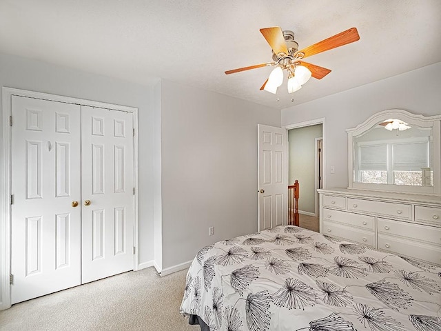 carpeted bedroom featuring ceiling fan and a closet