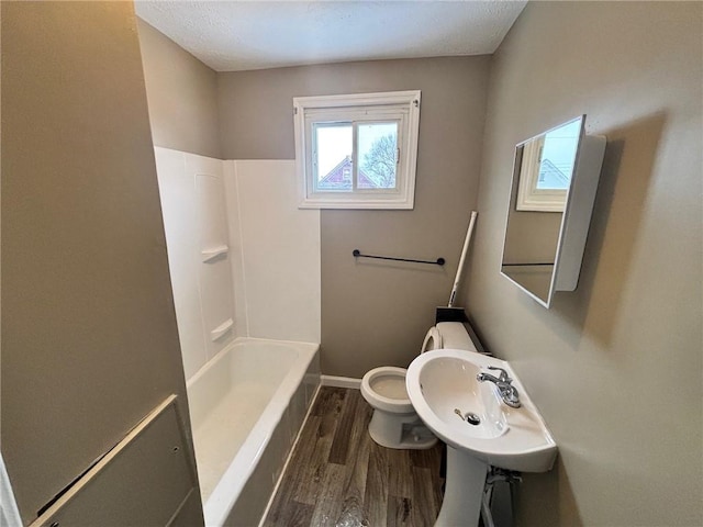 bathroom featuring toilet, shower / bath combination, and hardwood / wood-style flooring