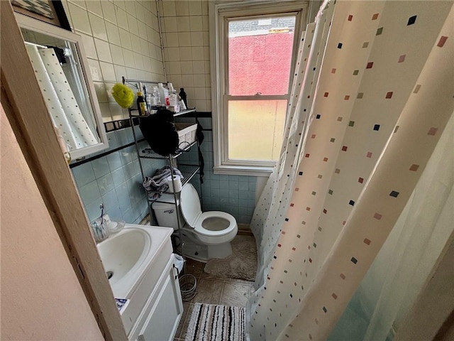 bathroom featuring vanity, toilet, and tile walls