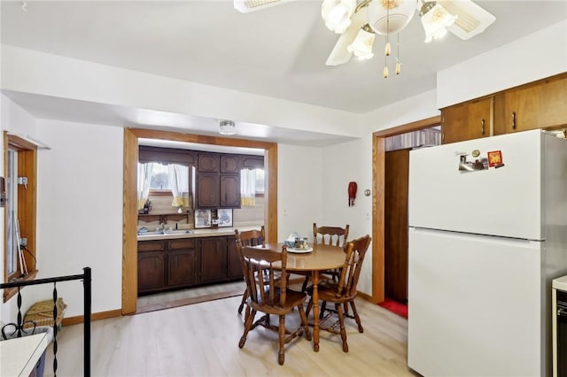 dining room with ceiling fan, light hardwood / wood-style flooring, and sink