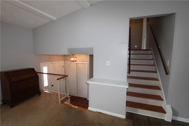 stairway featuring vaulted ceiling with beams