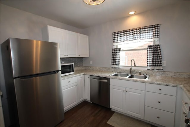 kitchen featuring decorative backsplash, sink, stainless steel appliances, white cabinets, and dark hardwood / wood-style flooring