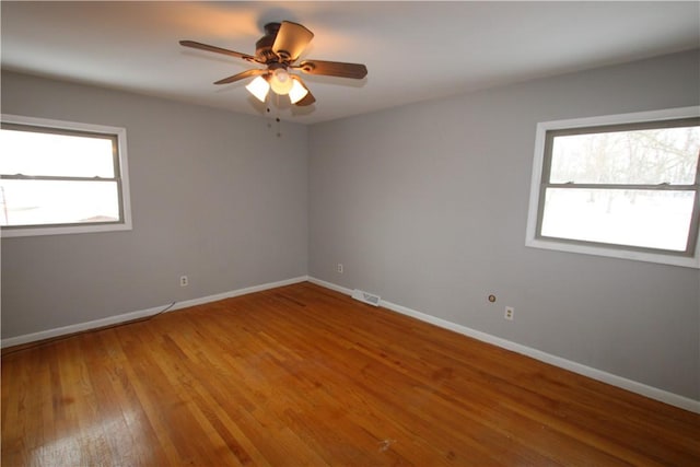 empty room with ceiling fan and hardwood / wood-style floors