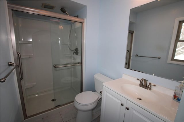 bathroom featuring a shower with shower door, tile patterned floors, vanity, and toilet