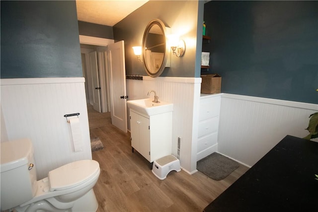 bathroom with hardwood / wood-style floors, toilet, and vanity