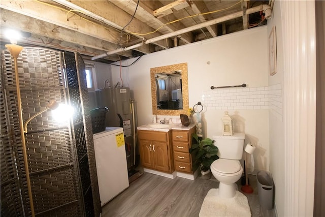 bathroom featuring toilet, vanity, electric water heater, wood-type flooring, and an enclosed shower