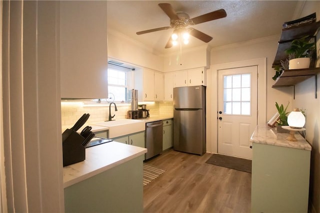 kitchen featuring white cabinetry, light hardwood / wood-style flooring, stainless steel appliances, and a healthy amount of sunlight