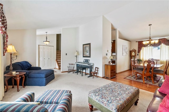 living room featuring vaulted ceiling, light hardwood / wood-style floors, and a notable chandelier