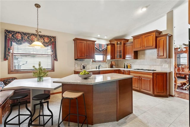 291 Annuity Dr, South Franklin, PA 15301 - kitchen with decorative backsplash, a center island, glass insert cabinets, pendant lighting, and brown cabinets