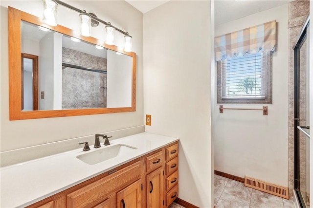 bathroom with a shower with shower door, tile patterned floors, and vanity