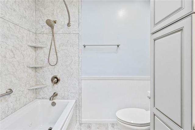 bathroom with toilet and tiled shower / bath