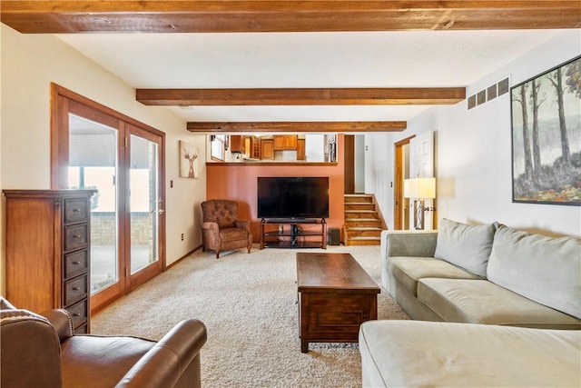 carpeted living room with french doors and beamed ceiling