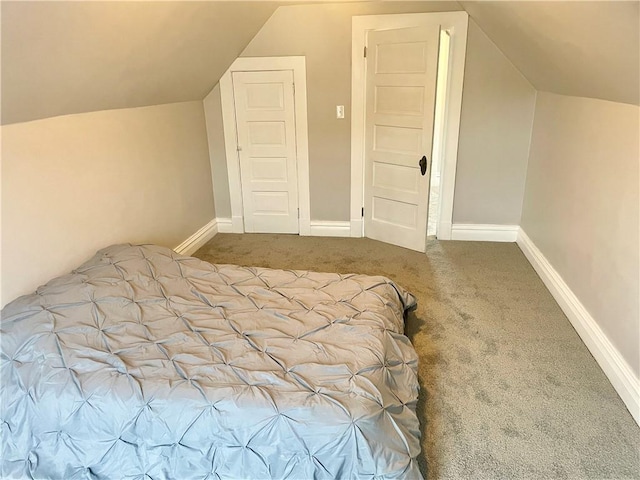 unfurnished bedroom featuring vaulted ceiling and carpet