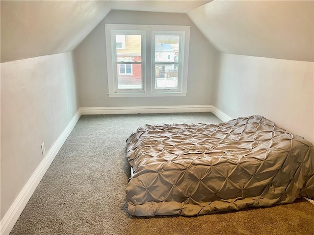 unfurnished bedroom with vaulted ceiling and carpet floors