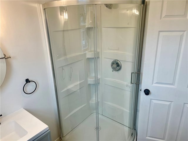 bathroom featuring vanity and a shower with door