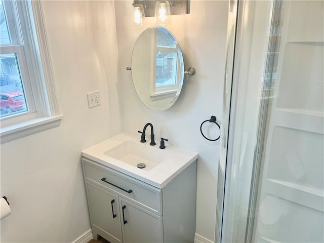 bathroom featuring a shower, a wealth of natural light, and vanity