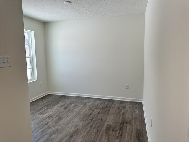 unfurnished room featuring dark hardwood / wood-style flooring and a textured ceiling