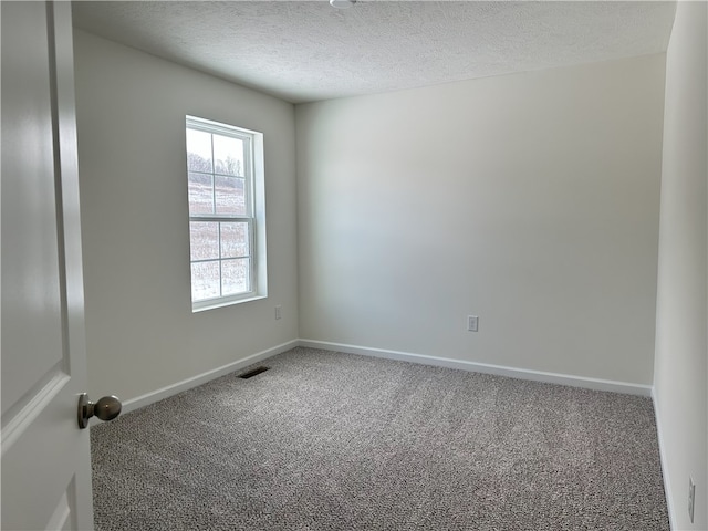 carpeted spare room featuring a textured ceiling