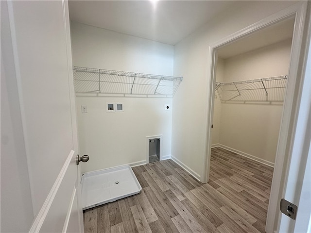 clothes washing area featuring washer hookup, electric dryer hookup, and light hardwood / wood-style flooring