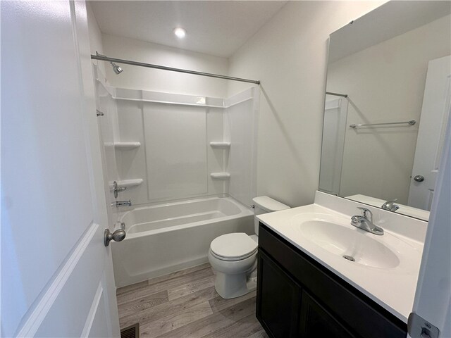 full bathroom with shower / tub combination, toilet, hardwood / wood-style flooring, and vanity