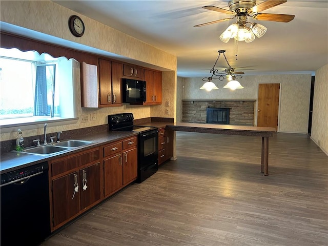 kitchen with ceiling fan, a fireplace, black appliances, sink, and dark wood-type flooring