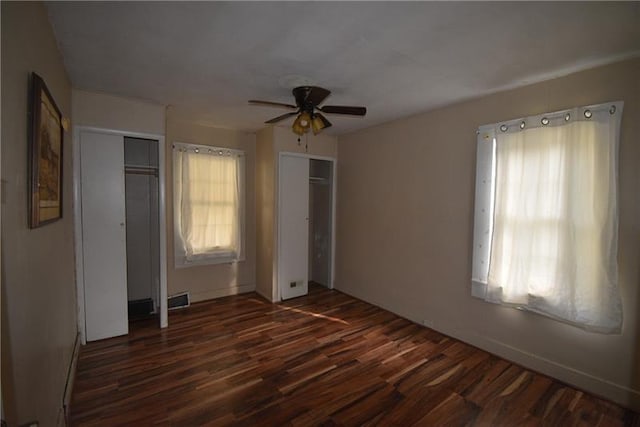 unfurnished bedroom with ceiling fan and dark hardwood / wood-style floors