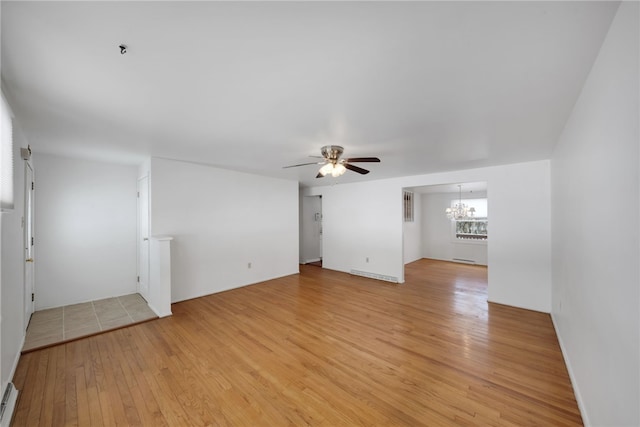 unfurnished living room featuring light wood-type flooring and ceiling fan with notable chandelier