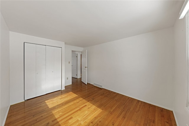 unfurnished bedroom featuring wood-type flooring and a closet