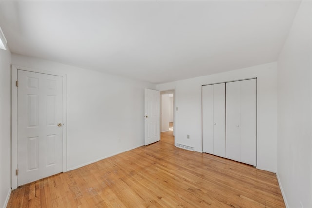 unfurnished bedroom featuring a closet and light hardwood / wood-style floors