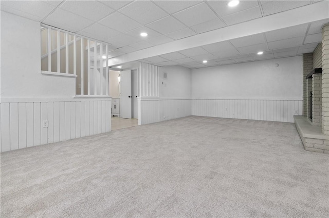 basement with a fireplace and light colored carpet