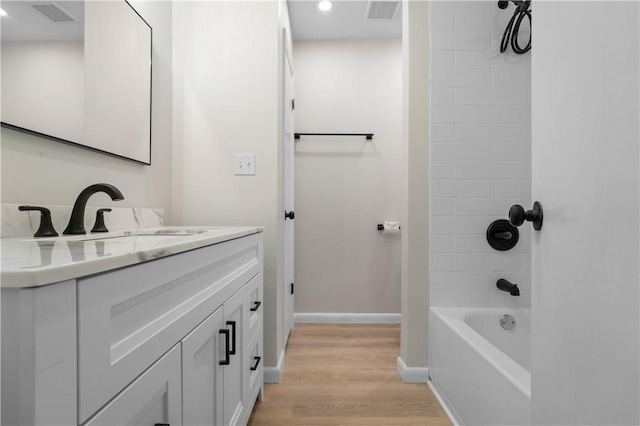 bathroom with shower / bathtub combination, wood-type flooring, and vanity