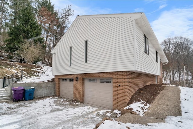 view of snowy exterior featuring a garage