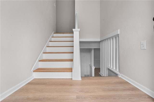 staircase with hardwood / wood-style floors