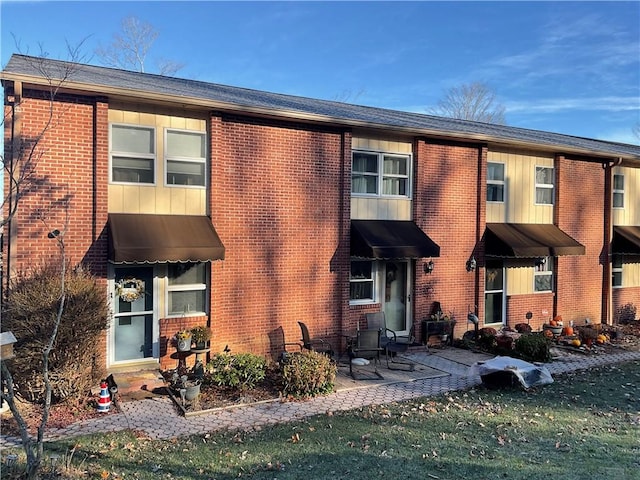 townhome / multi-family property featuring a front lawn and a patio area