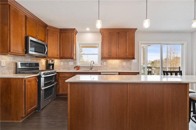 kitchen featuring decorative light fixtures, a kitchen breakfast bar, sink, and stainless steel appliances