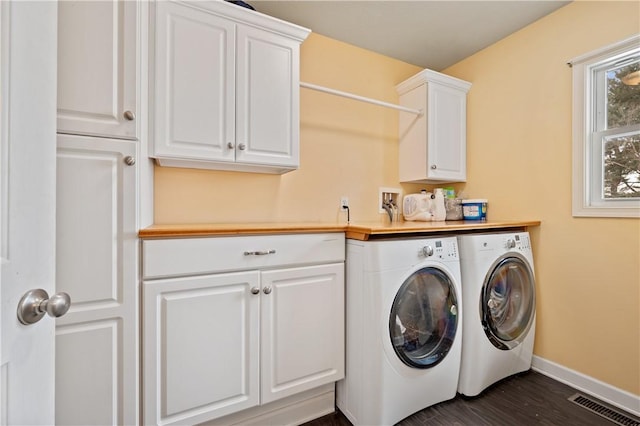 washroom with cabinets, dark hardwood / wood-style flooring, and washing machine and dryer